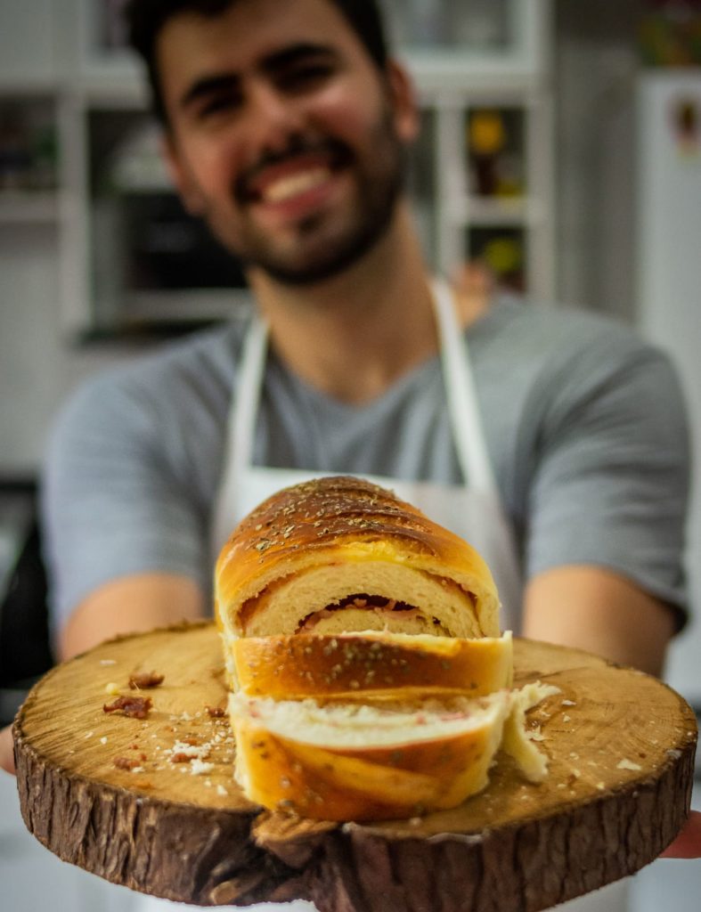 homem segurando uma bandeja de pães